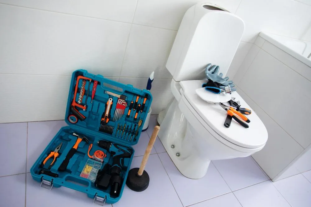 Open toilet tank showing the flapper, fill valve and overflow tube that cause a running toilet