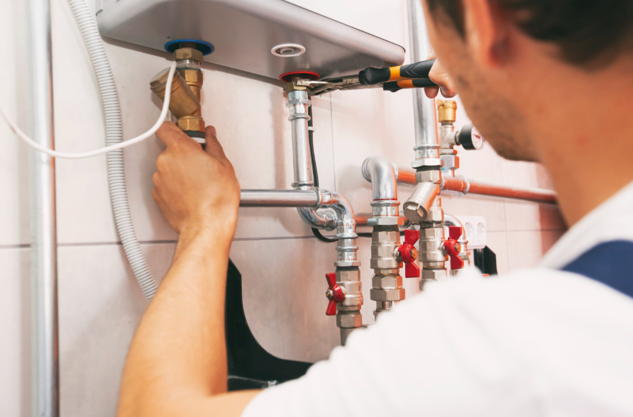 Technician inspecting boiler valves and connections before winter in a Philadelphia home